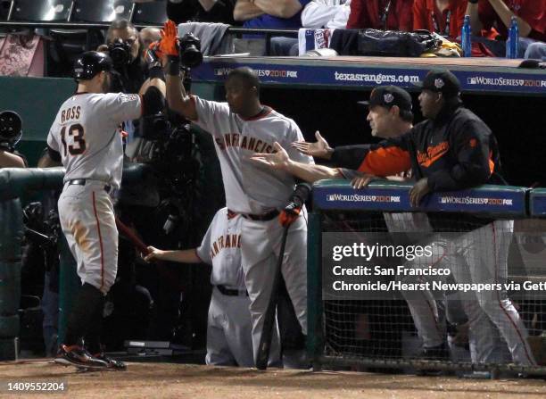 San Francisco Giants center fielder Cody Ross is greeted at the dugout by teammates after hitting a solo homer in the 7th inning making the score 4-1...