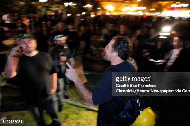 Two Occupy Oakland protesters argue whether to remove chain link fence from where the group's camp had previously been located in Frank Ogawa Plaza....