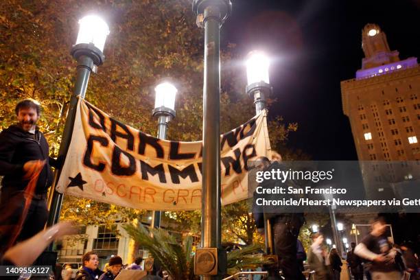 An Occupy Oakland protester restore their banner to where the group's camp had previously been located in Frank Ogawa Plaza in Oakland, Calif, on...