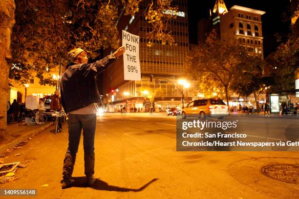 Theresa Wilson of Concord rallies support from passing motorists on 14th Street as Occupy Oakland protesters returned to Frank Ogawa Plaza in...
