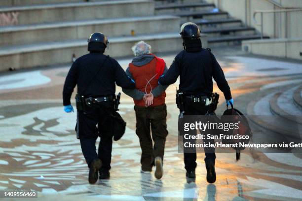 Protester is led away in handcuffs as police from various agencies moved in to clear out Occupy Oakland protesters and their tents from Frank Ogawa...