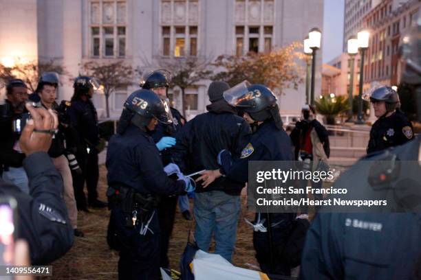 Protester is hancduffed after being removed from a tent as police from various agencies moved in to clear out Occupy Oakland protesters and their...