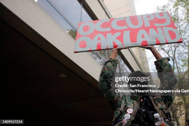 Member of Occupy Oakland holds up a sign outside of the Wiley M. Manuel Courthouse in Oakland, Calif., Monday, to show support for several...