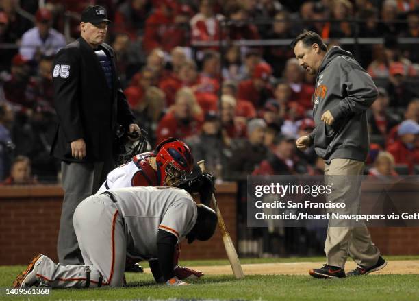 Giants trainer Dave Groeschner comes to check on Pablo Sandoval who fouled a ball off his foot in the first inning. The San Francisco Giants played...