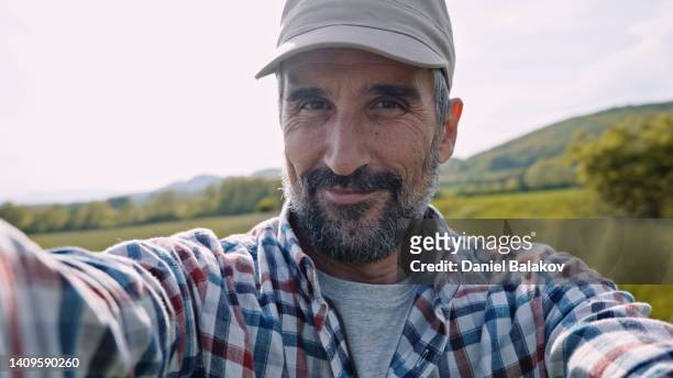 farmer vlogging in wheat crops at sunset in spring. - corporate portraits depth of field stockfoto's en -beelden