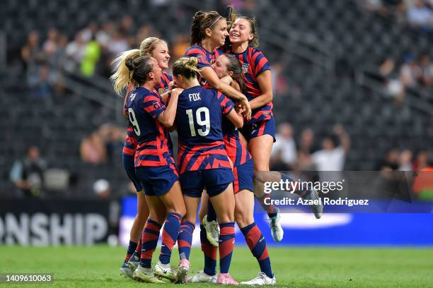 Alex Morgan of USA celebrates with teammates after scoring her team's first goal during the championship match between United States and Canada as...