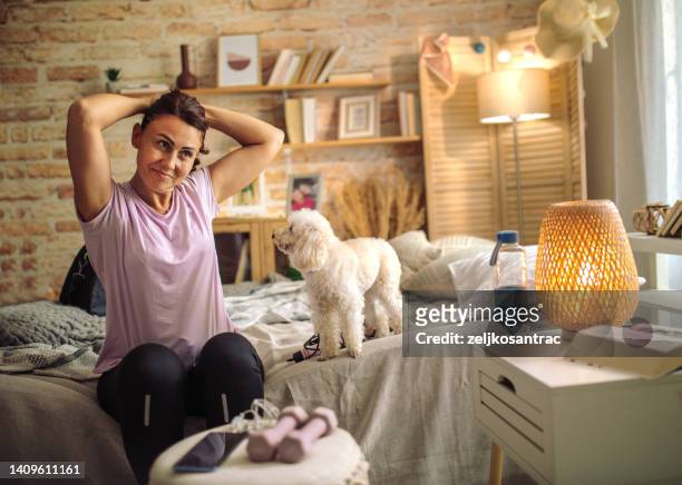 woman getting ready for a workout - tied to bed stockfoto's en -beelden