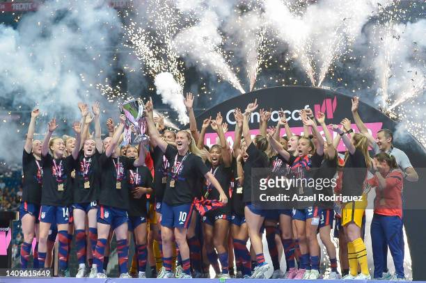 Becky Sauerbrunn and Lindsey Horan of USA lift the champion's trophy after winning the championship match between United States and Canada as part of...