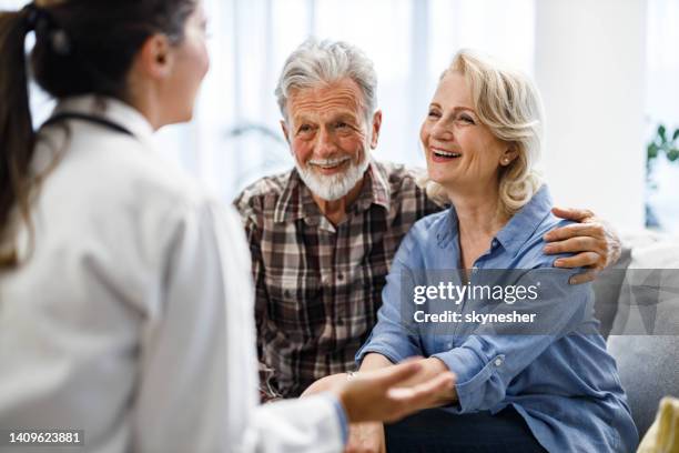 feliz pareja madura hablando con su médico durante su visita al hogar. - medicare fotografías e imágenes de stock