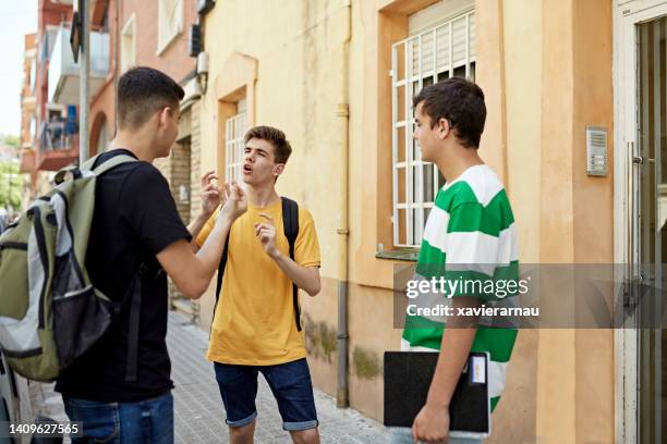 deaf friends pausing to sign on barcelona side walk - group of people using sign language stock pictures, royalty-free photos & images