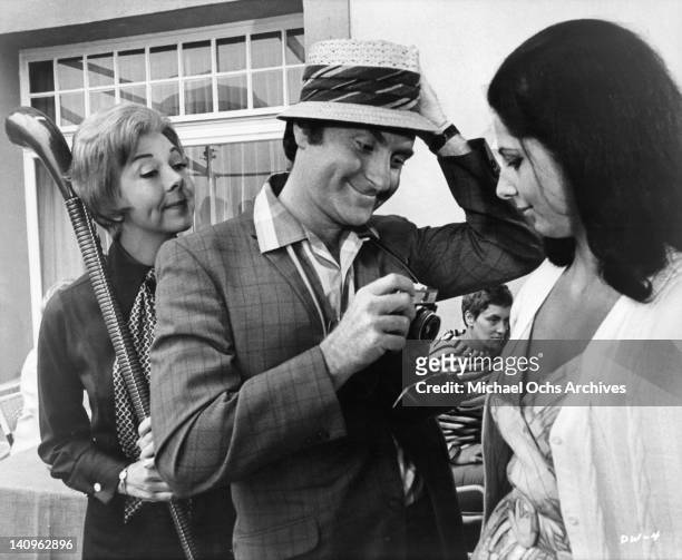 Marty Ingels taking picture of woman's cleavage in a scene from the film 'If It's Tuesday, This Must Be Belgium', 1969.