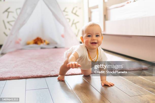 baby girl crawling on the floor at home - crawling stock pictures, royalty-free photos & images