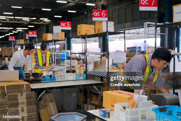 blue collar workers at warehouse. - warehouse packing stock pictures, royalty-free photos & images