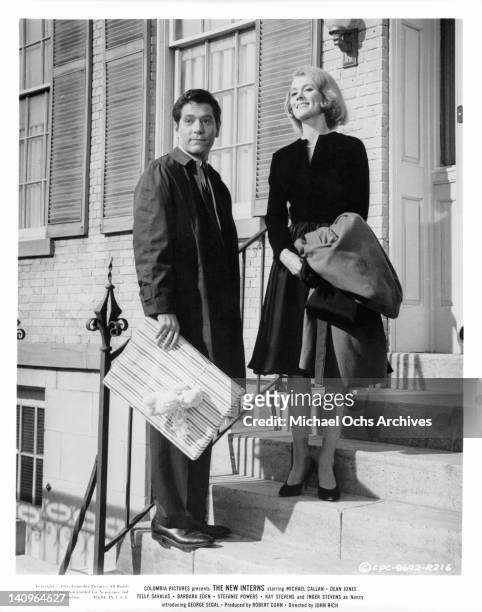 George Segal and Inger Stevens on front steps in a scene from the film 'The New Interns', 1964.