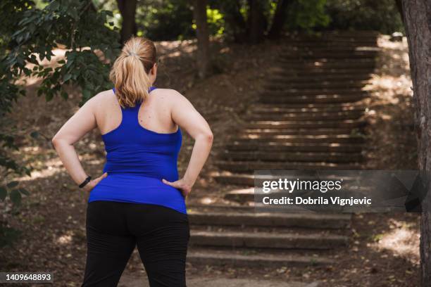 rückansicht einer frau, die vor einer treppe im park steht - frauen über 30 stock-fotos und bilder