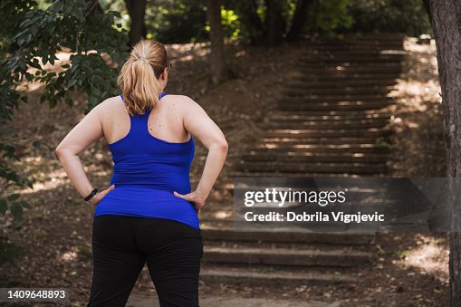 Rear view of a woman standing in front of stairs in the park Rear view of a woman standing in front of stairs in the park