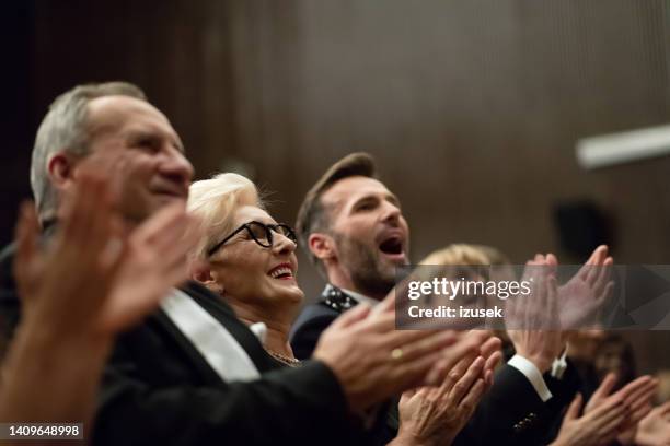 aufgeregtes publikum klatscht im theater - kinobesucher stock-fotos und bilder