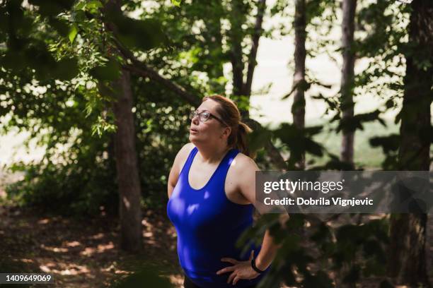 woman resting in a forest after outdoor workout - breathing new life stock pictures, royalty-free photos & images