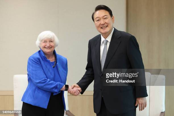 In this handout image provided by the South Korean Presidential Office, South Korean President Yoon Suk-yeol shakes hands with U.S. Treasury...