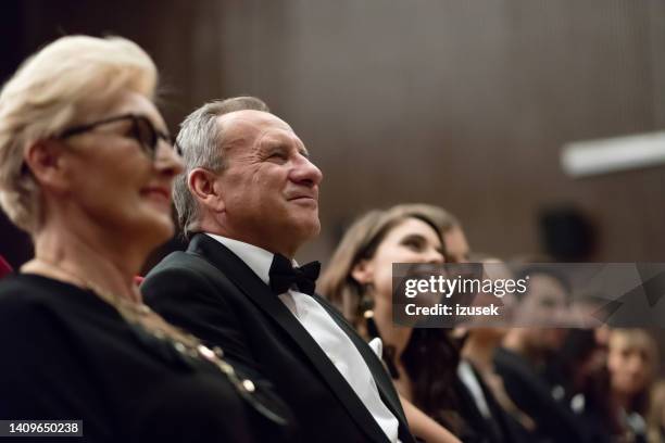 smiling spectators sitting in the theater - arts for humanity gala imagens e fotografias de stock