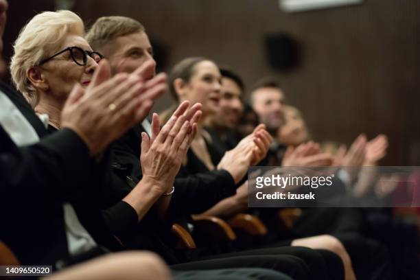 spectators clapping in the theater - british film reception inside stock pictures, royalty-free photos & images