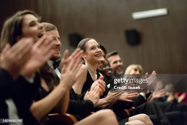 spectators clapping in the theater - british film reception inside stock pictures, royalty-free photos & images