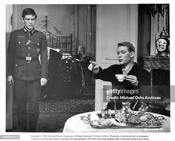 Tom Courtenay stands as Peter O'Toole points his finger forward in a scene from the film 'Night Of The Generals', 1966.