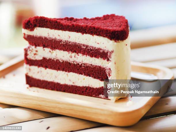 birthday cake piece red velvet with whipped cream on wooden tray - cake slices stock-fotos und bilder