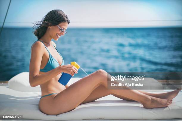 ich kümmere mich jedes mal um meine haut, wenn ich in die sonne gehe. - hot women on boats stock-fotos und bilder