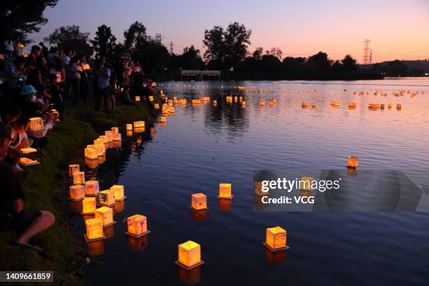 People hold lanterns before releasing them into water at Legg Lake Park during the Water Lantern Festival on July 16, 2022 in South El Monte,...