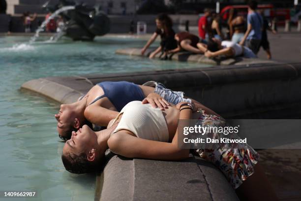 Two women dip their heads into the fountain to cool off in Trafalgar Square on July 19, 2022 in London, United Kingdom. Temperatures were expected to...