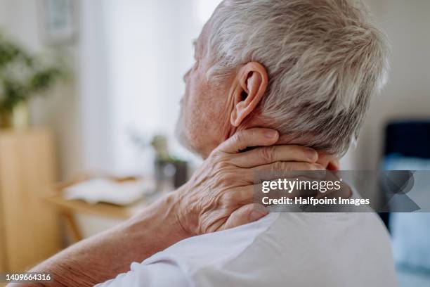 close-up of senior man having pain in his neck. - menschlicher hals stock-fotos und bilder