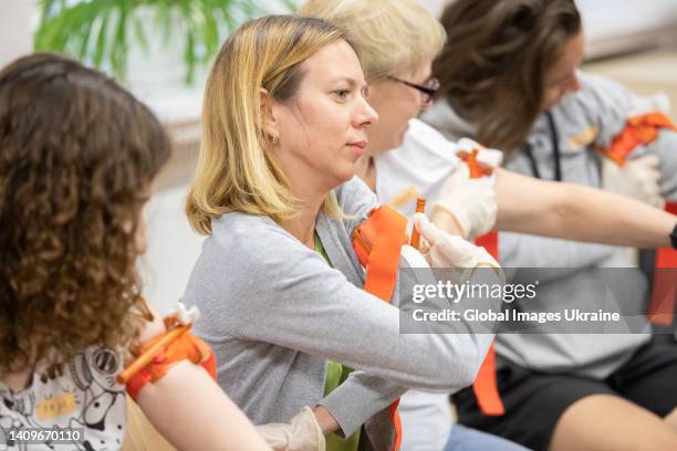 Participants of first aid class practice how to apply a tourniquet on July 11, 2022 in Kyiv, Ukraine. Under martial law and constant shelling, anyone...