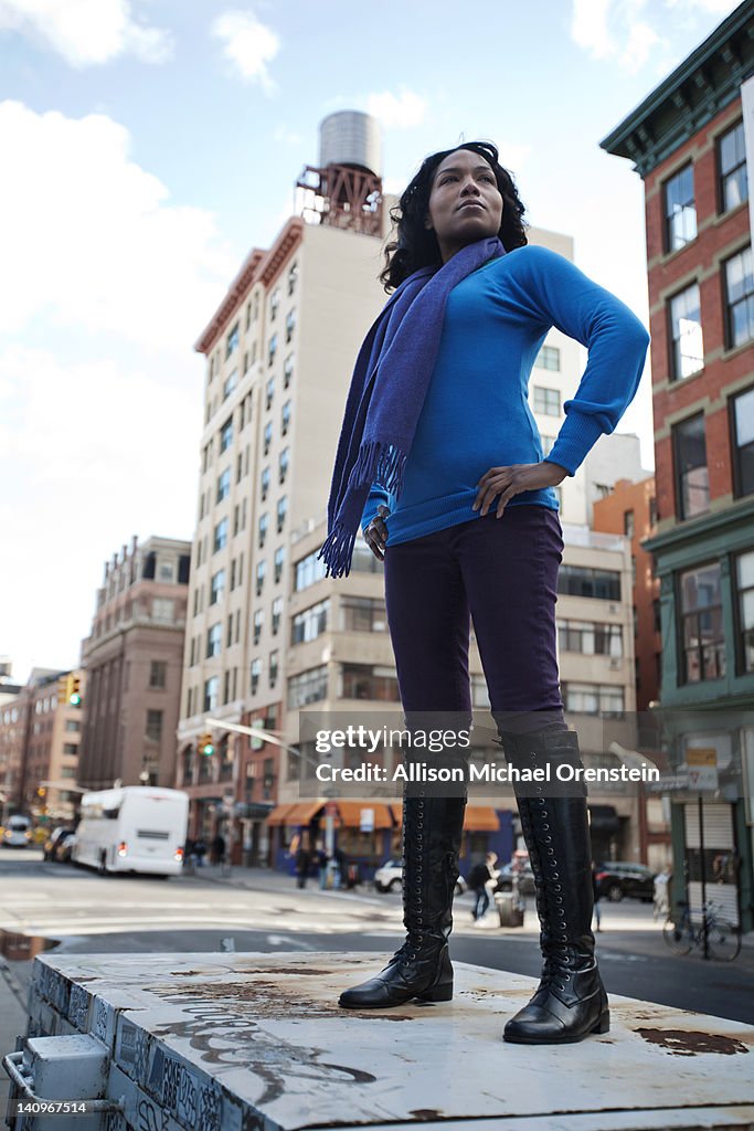 Woman standing up high in city