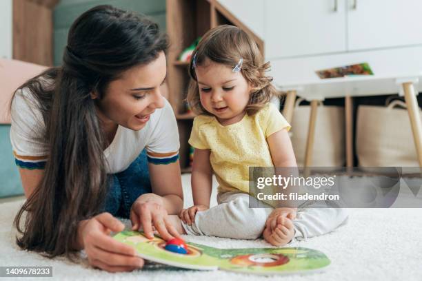 madre e hija leyendo libro - madre ama de casa fotografías e imágenes de stock