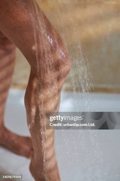 water cascading over woman's leg in shower - legs in water fotografías e imágenes de stock