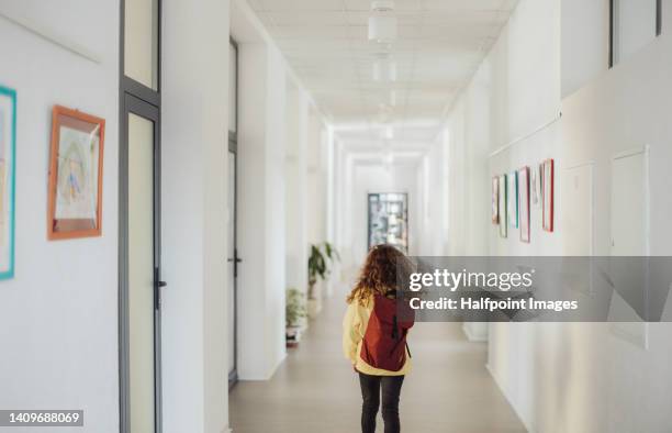 rear view of little girl walking in school corridor. - endast en flicka bildbanksfoton och bilder