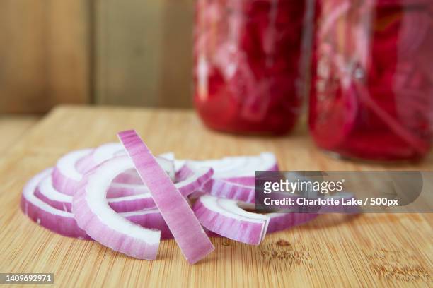 close-up of sliced onions on cutting board - gemüsezwiebel stock-fotos und bilder