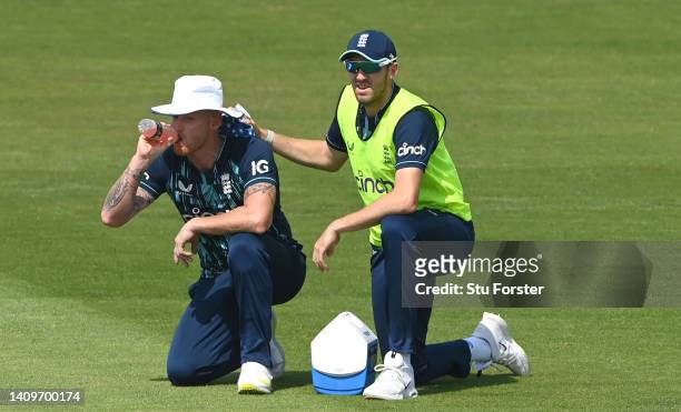 12th man Craig Overton applies an ice pack onto the neck of England bowler Ben Stokes during a break in play as the sun beats downduring the First...