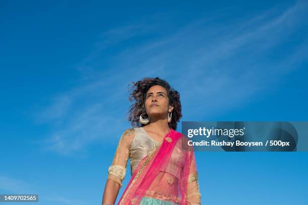 woman in traditional indian wear looking upwards,gqeberha,south africa - editorial woman stock pictures, royalty-free photos & images