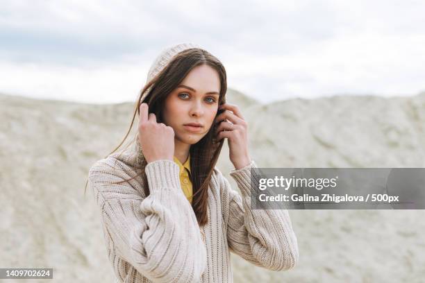 fyoung woman with long hair in knitted cardigan on desert background,autumn outfit - hair editorial stock pictures, royalty-free photos & images