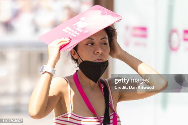 Woman covers her face from the sun on the Southbank on July 19, 2022 in London, United Kingdom. Temperatures were expected to hit 40C in parts of the...