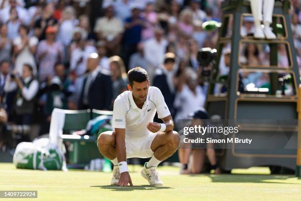 Novak Djokovic of Serbia celebrates by eating a piece of grass after winning the Mens Singles Final against Nick Kyrgios of Australia at The...