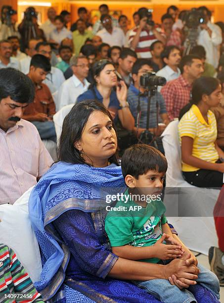 Wife of Indian cricketer Rahul Dravid, Dr. Vijeta Pendharkar Dravid and their son, sit amongst journalists watching Dravid address a press conference...