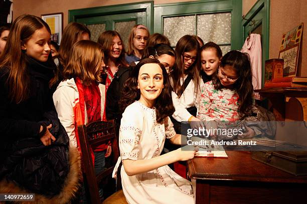 Children watch the wax figure of Anne Frank and their hideout reconstruction at Madame Tussauds on March 9, 2012 in Berlin, Germany.