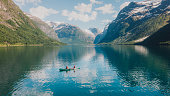 Aerial view of woman and man contemplating summer in Norway canoeing in the lake Lovatnet