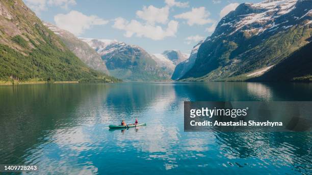 aerial view of woman and man contemplating summer in norway canoeing in the lake lovatnet - norway imagens e fotografias de stock