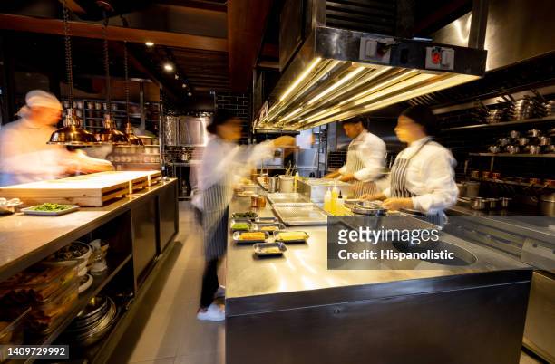 cocineros agitados trabajando en una concurrida cocina comercial en un restaurante - cocina comercial fotografías e imágenes de stock
