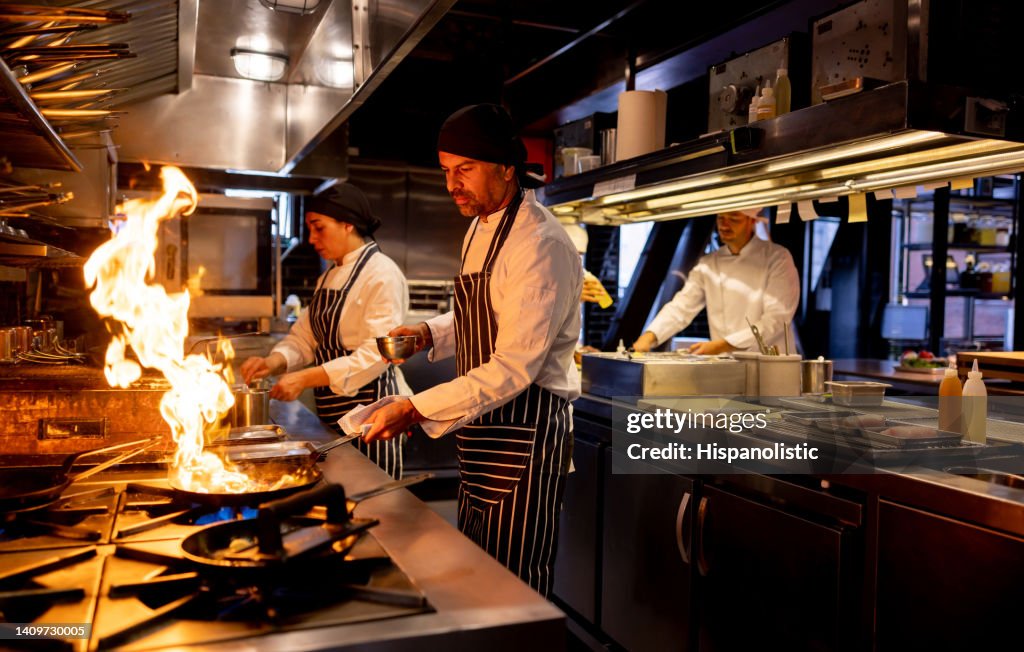 Chef cooking at a restaurant and flaming the food