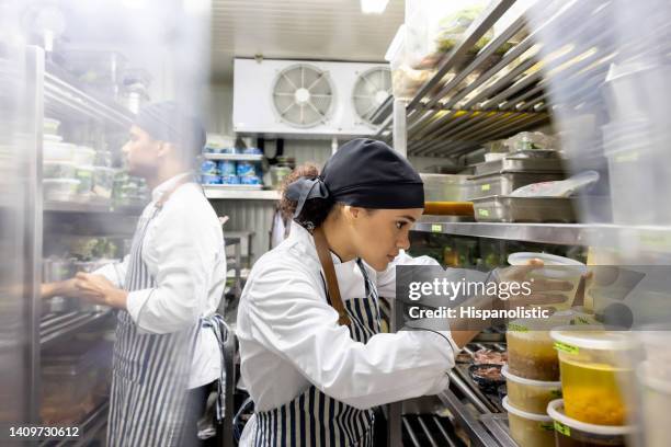 cooks working at a restaurant and looking for ingredients in the pantry - chef kitchen stockfoto's en -beelden